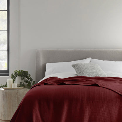 Whisper Organics Organic Cotton Woven Blanket, Burgundy – on a bed